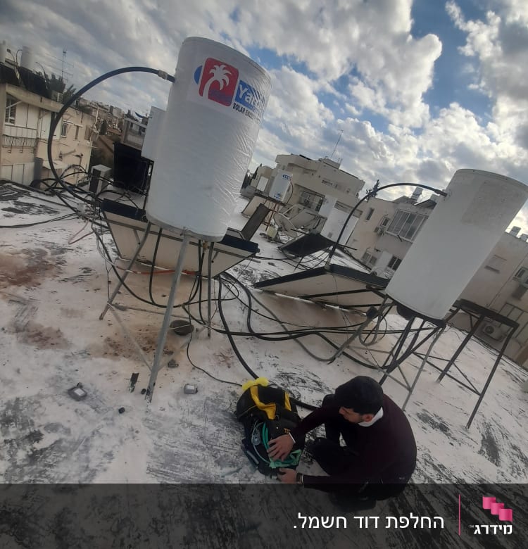 דוד שמש על גג עם אדם מתקן צנרת